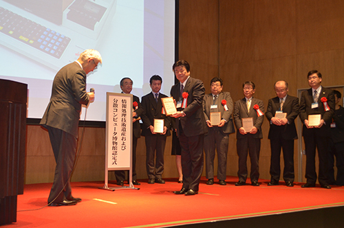 2013年3月6日，KCGI和KCG总裁长谷川渡在仙台的东北大学接受表彰牌。