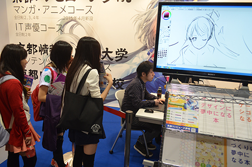 参观者热情地看着锅岛哲宏的现场绘画（Miyako Messe）。