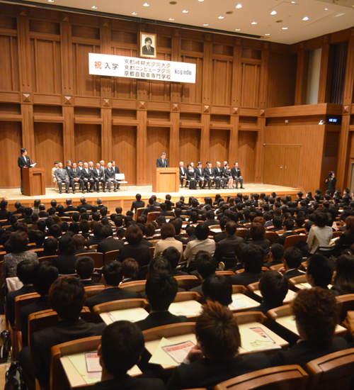 Lễ khai giảng của Trường Sau Đại học Công nghệ Thông tin Kyoto 2015, Học viện Máy tính Kyoto, Trung tâm Đào tạo Tiếng Nhật Kyoto và Trường Kỹ thuật nghề Ô-tô Kyoto, được tổ chức tại Đại học Kyoto (ngày 5 tháng 4 năm 2015, Hội trường lớn vệ tinh trước nhà ga Kyoto Trường Sau Đại học Công nghệ Thông tin Kyoto)