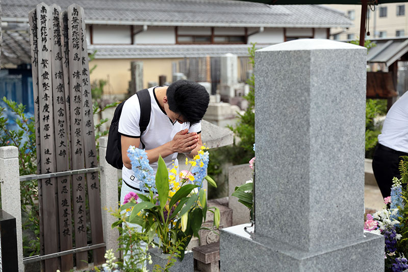 Sinh viên và giảng viên lặng lẽ bắt tay nhau tại ngôi mộ ở Hyakuen